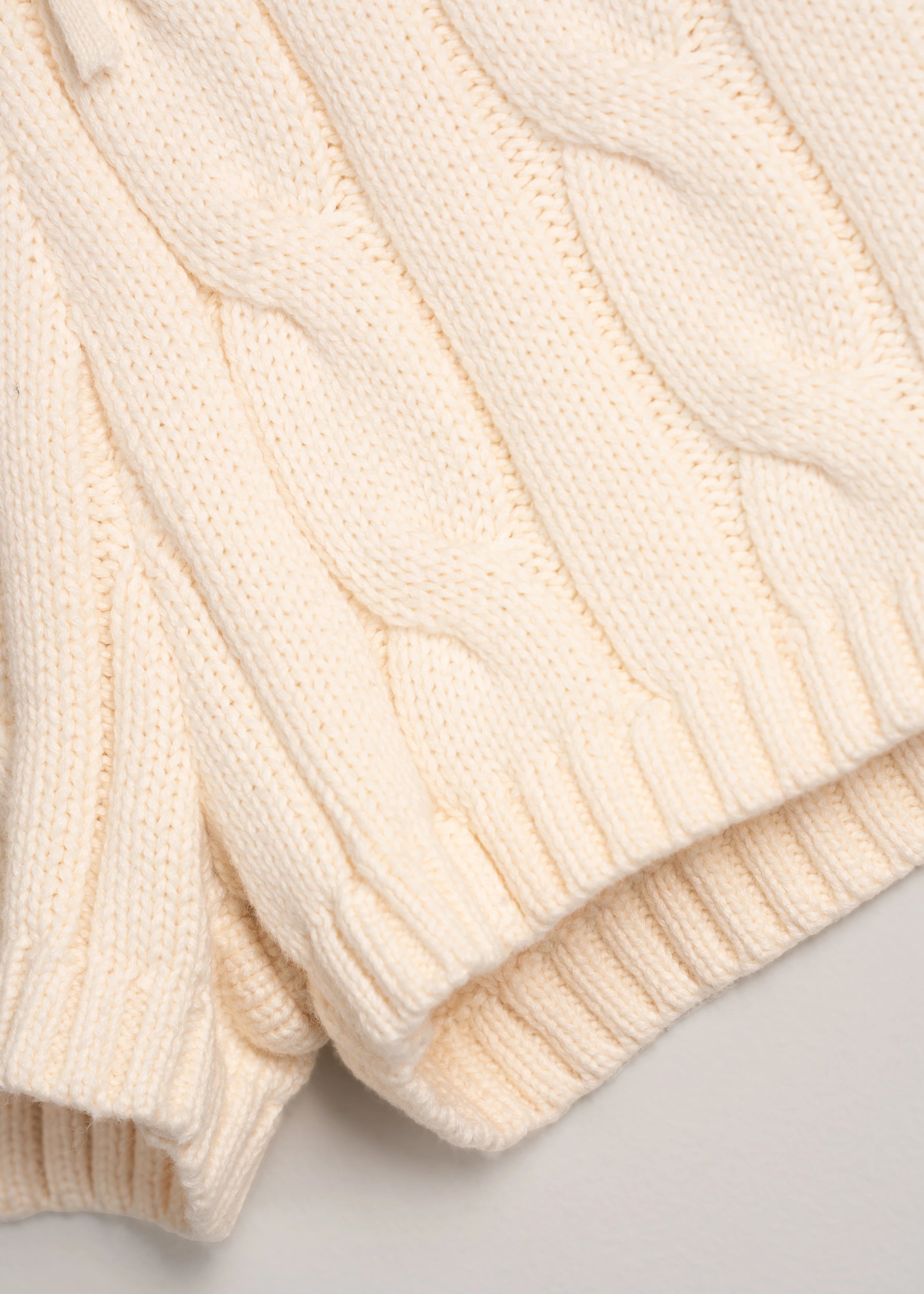 La Corsia Cable Knit Mini Short in cream, made from heavyweight cotton with a fitted silhouette, ribbed waistband, and chunky cable texture throughout.