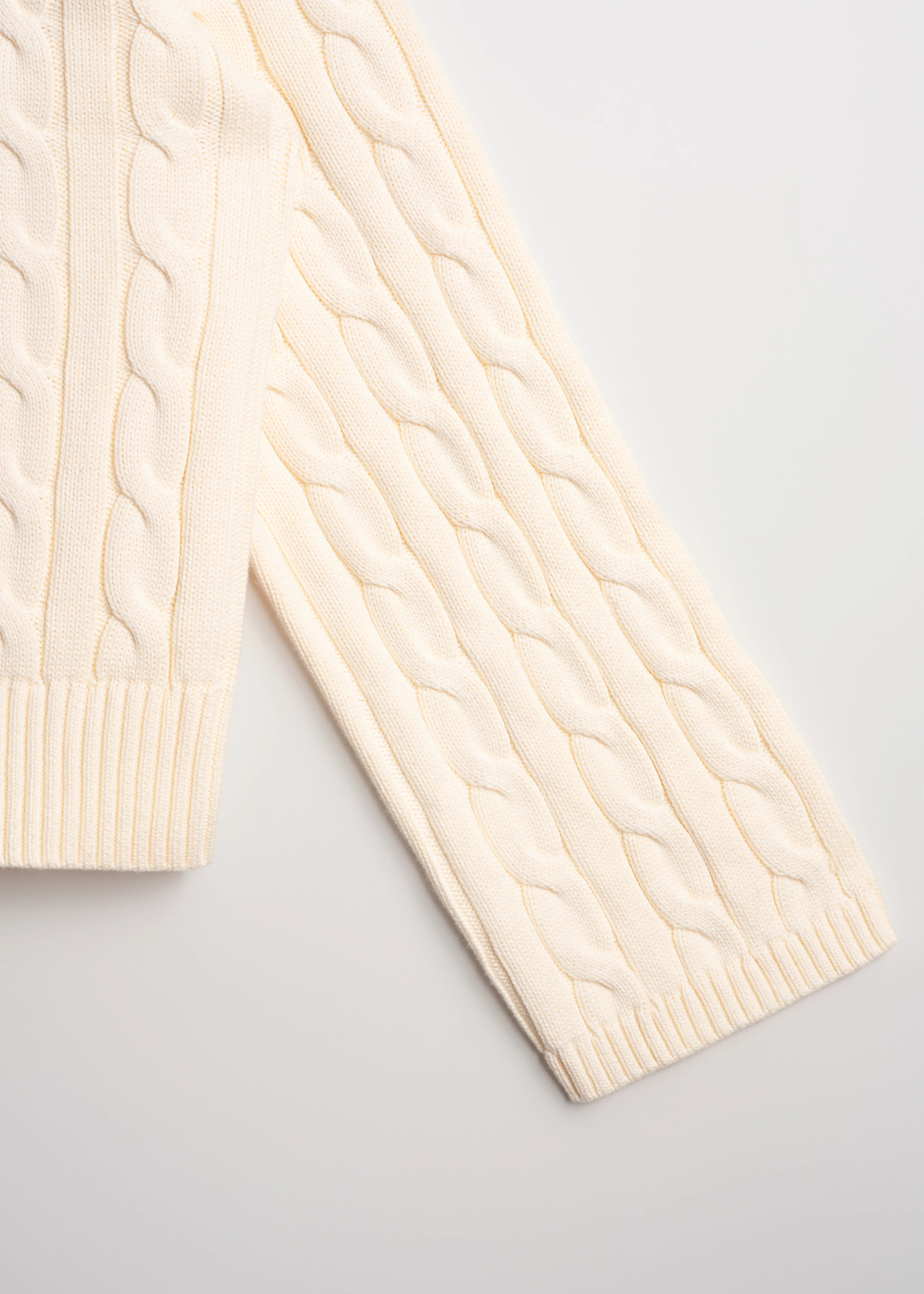 La Corsia Wide Sleeve Cable Knit sweater in cream, crafted from heavyweight cotton with a quarter zip, funnel neck, and sculpted oversized silhouette.