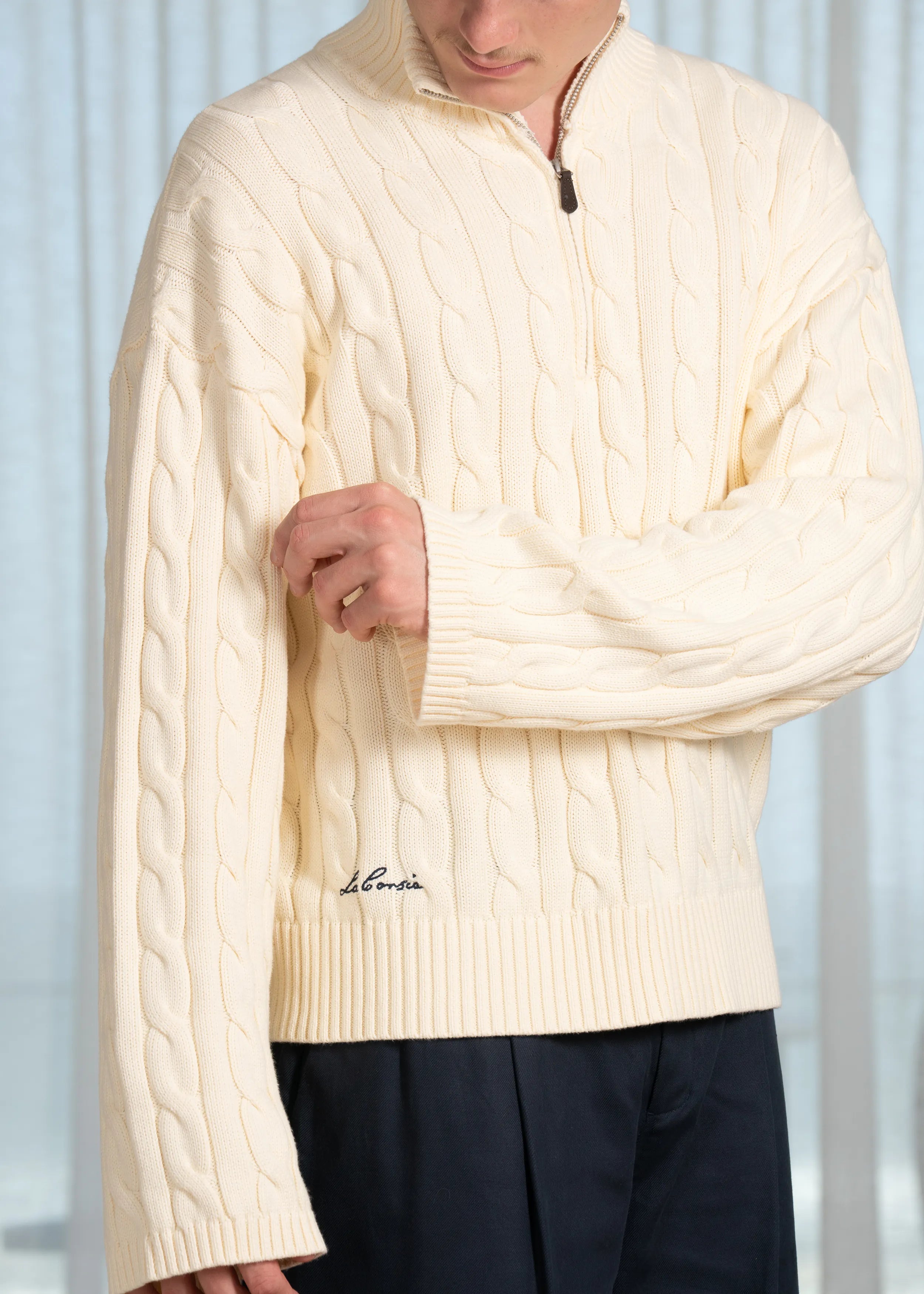 La Corsia Wide Sleeve Cable Knit sweater in cream, crafted from heavyweight cotton with a quarter zip, funnel neck, and sculpted oversized silhouette.