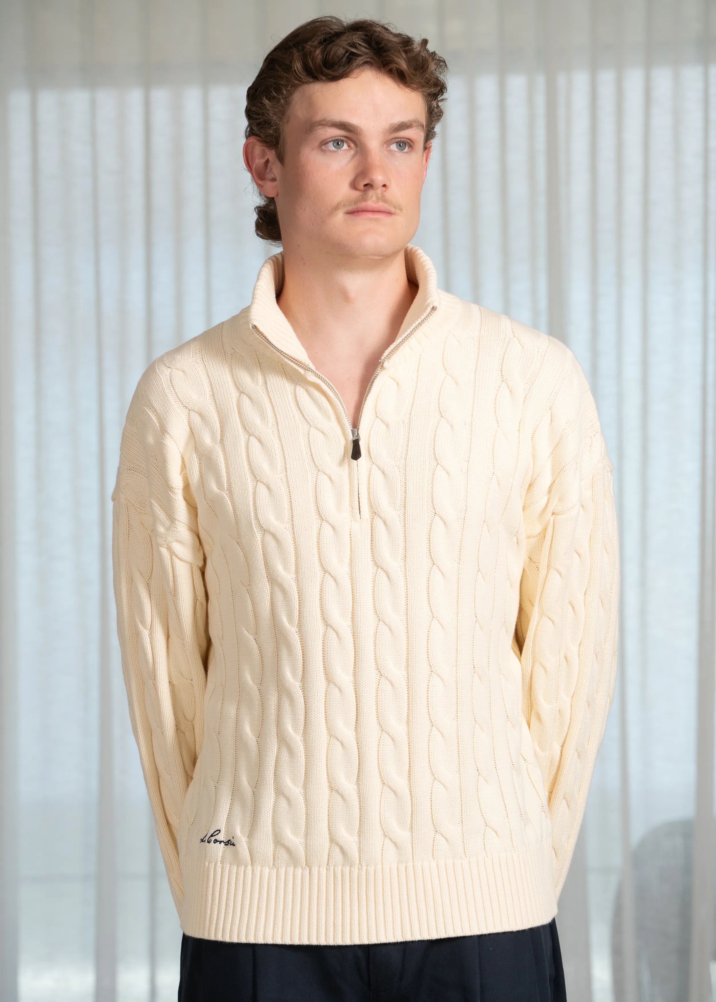 La Corsia Wide Sleeve Cable Knit sweater in cream, crafted from heavyweight cotton with a quarter zip, funnel neck, and sculpted oversized silhouette.