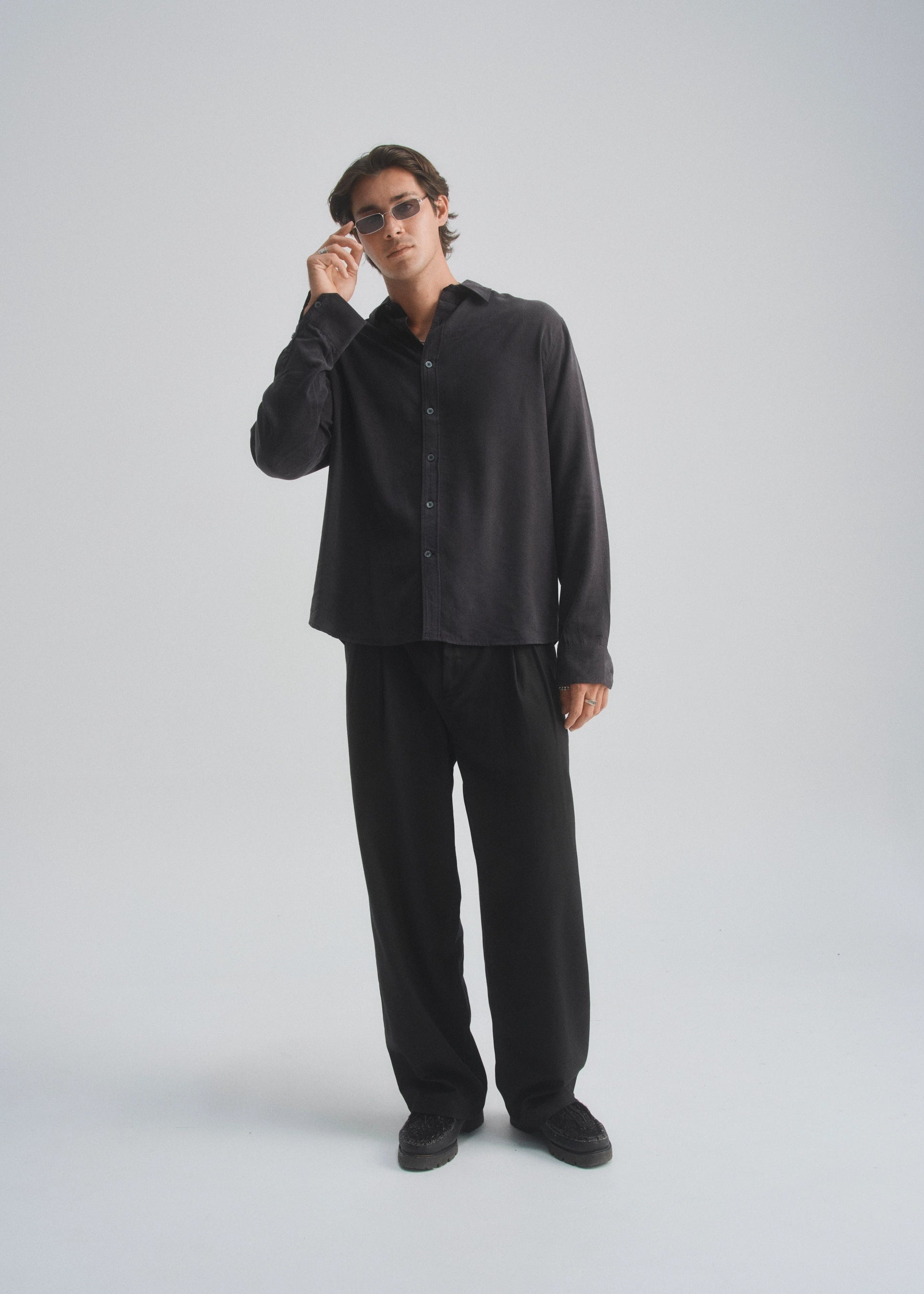 Man wearing a black shirt and pants on a white background