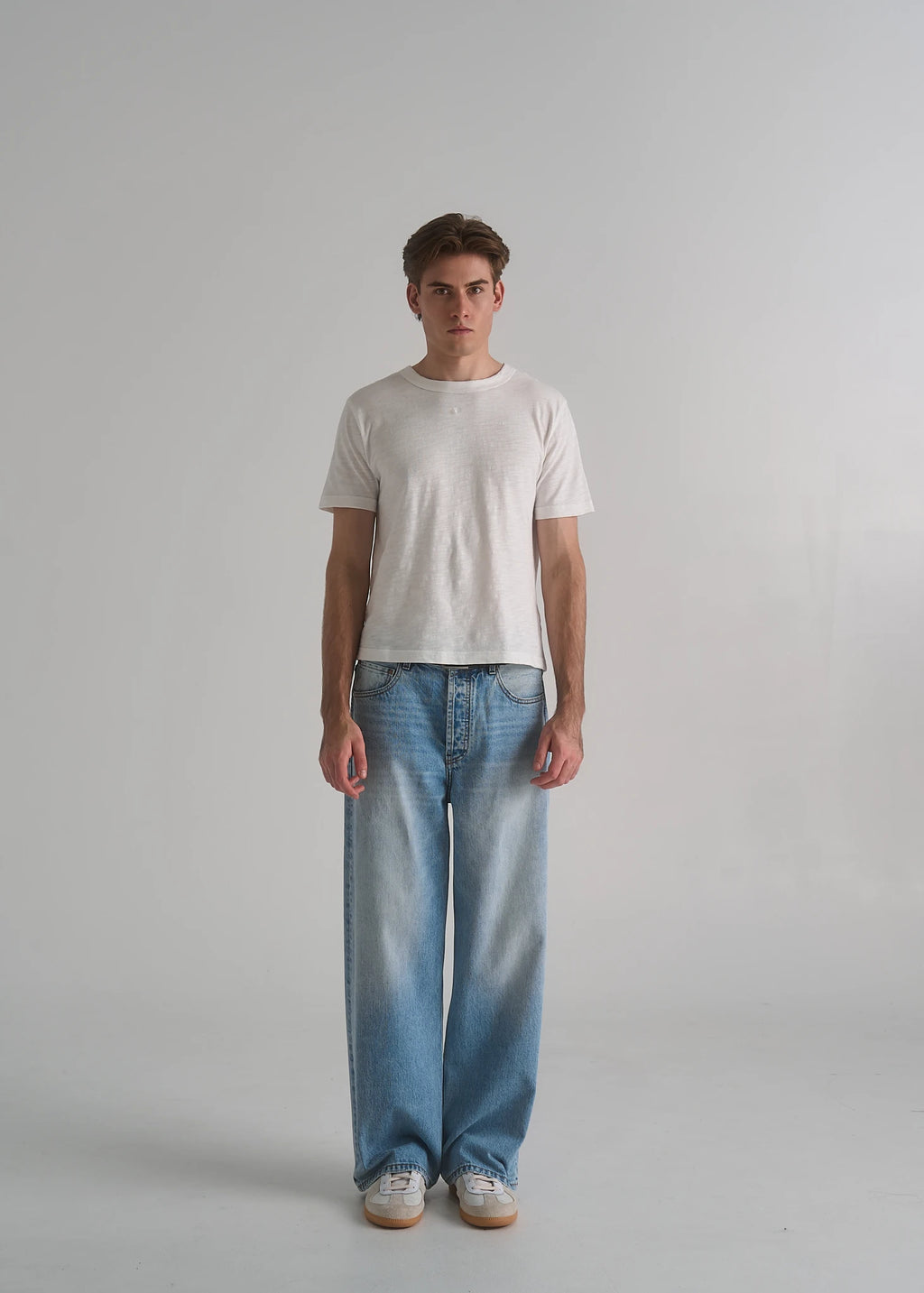 La Corsia Vintage Wash Relaxed Denim in light blue worn by a model on a plain studio background