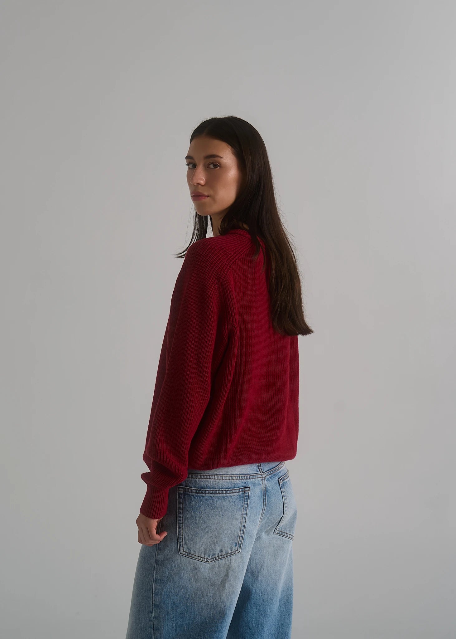 Model wearing the La Corsia Cotton Fisherman Sweater in wine red with the Vintage Wash Relaxed Denim in light blue