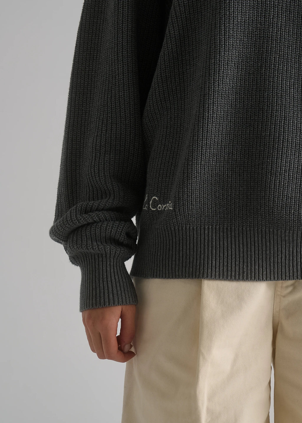 La Corsia Cotton Fisherman Sweater in grey marle worn by a model on a plain studio background
