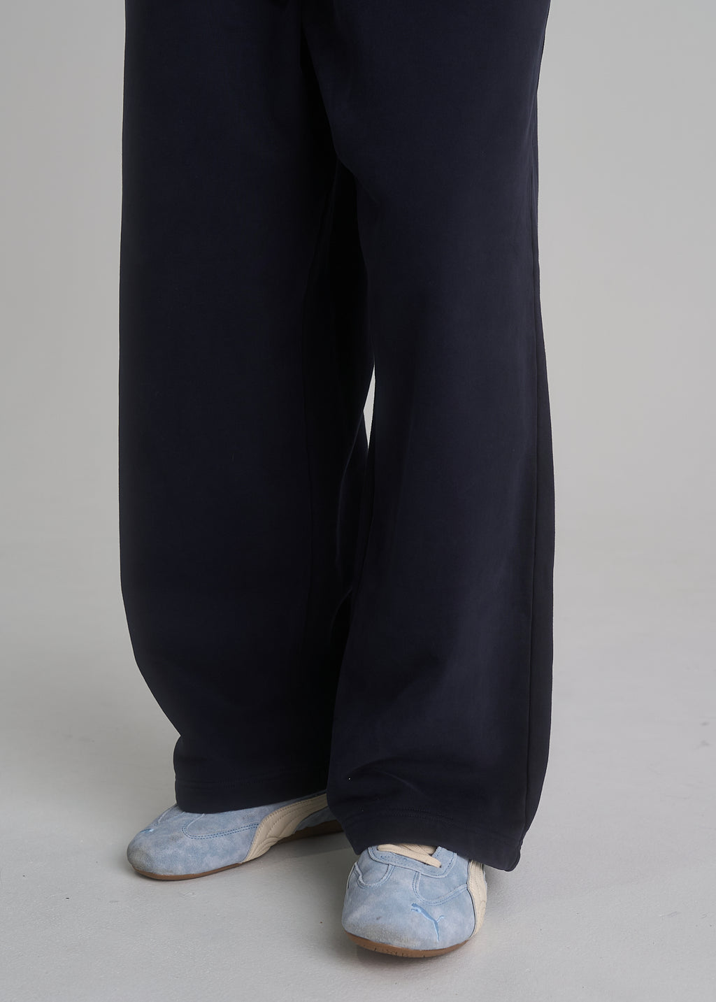 La Corsia Oversized Track Pant in washed navy worn by a model on a plain studio background