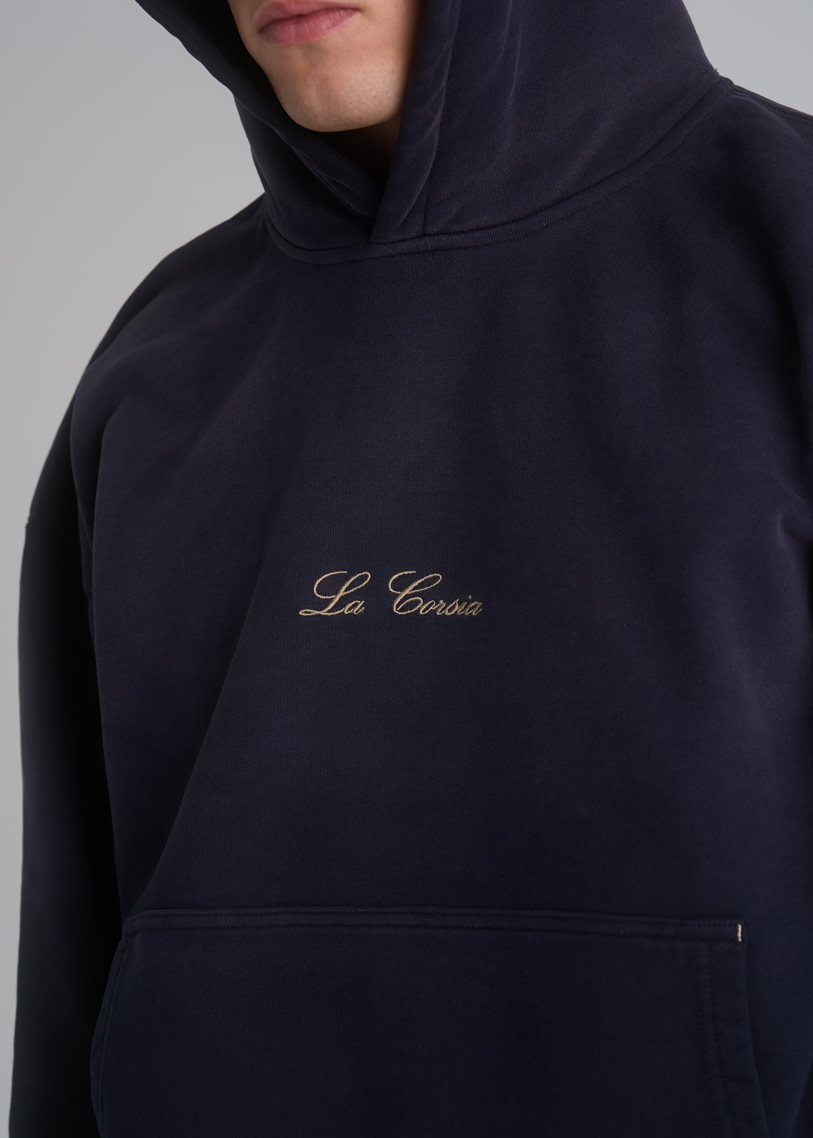 Model wearing the La Corsia Washed Script Hoodie in washed navy