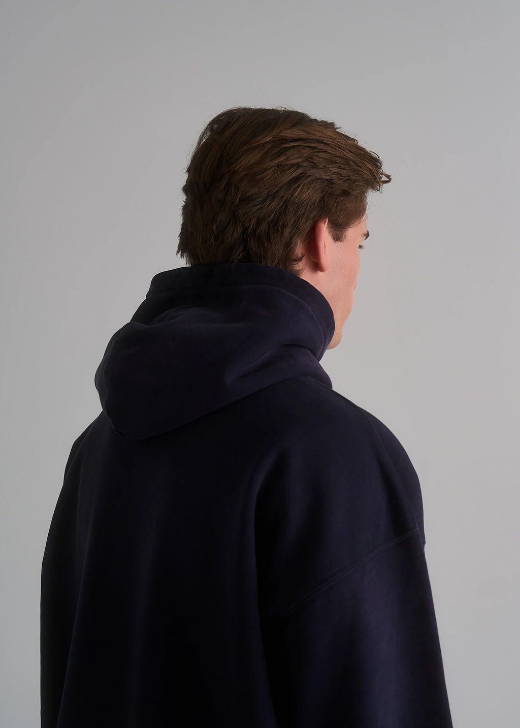 La Corsia Washed Script Hoodie in washed navy worn by a model on a plain studio background
