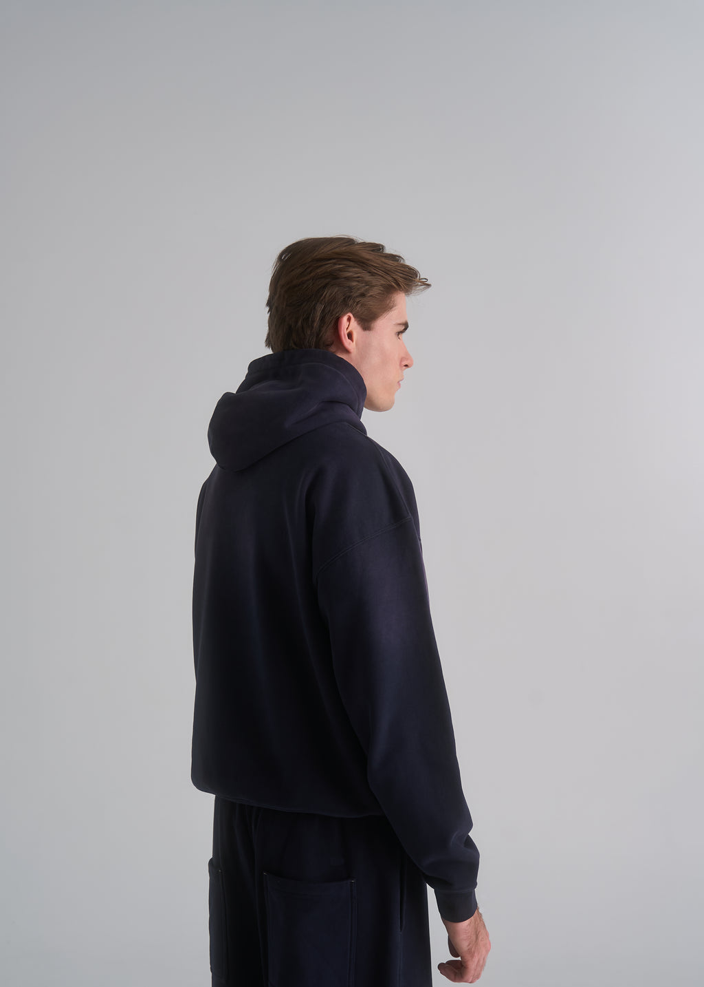 Model wearing the La Corsia Washed Script Hoodie in washed navy