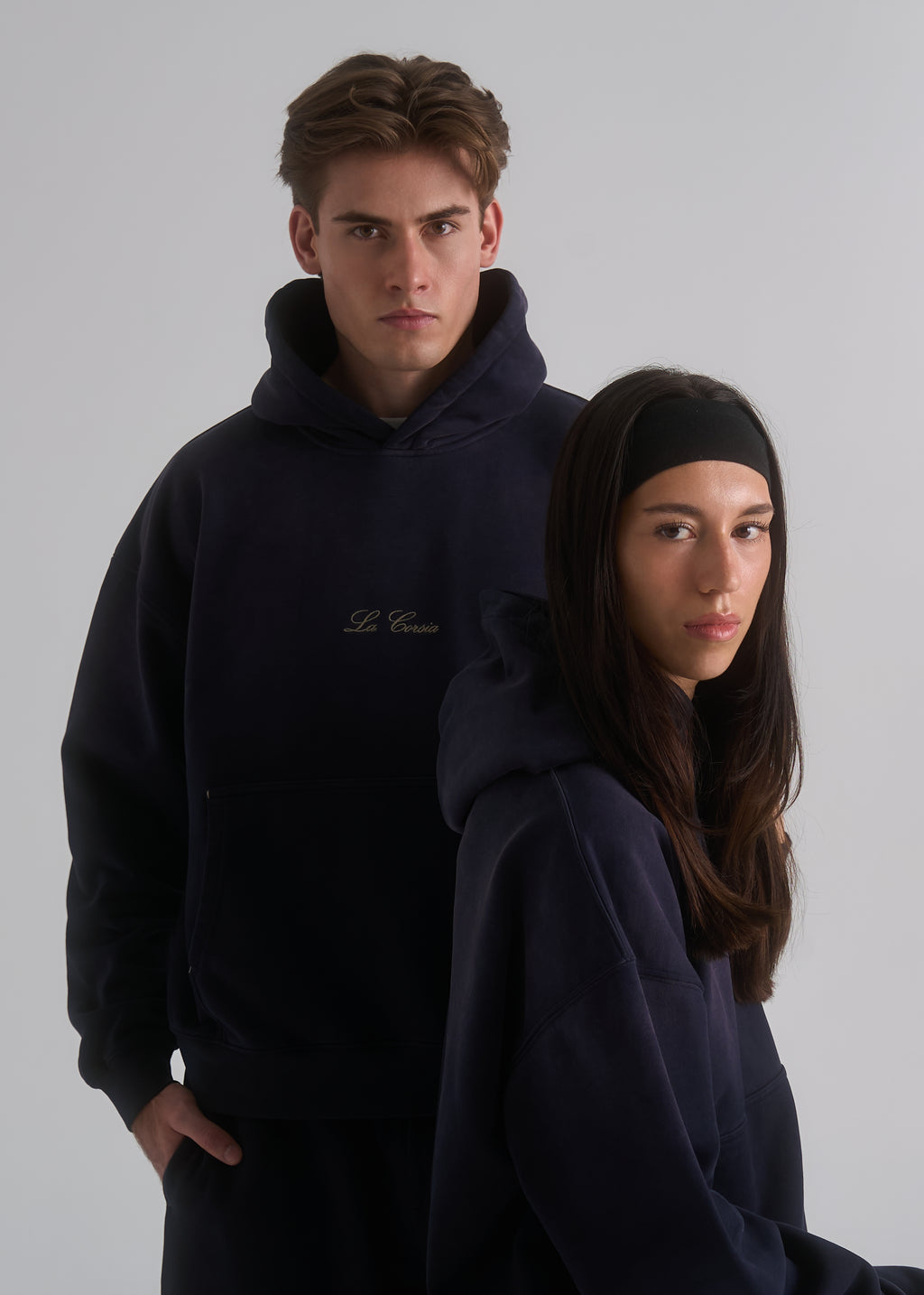 La Corsia Washed Script Hoodie in washed navy worn by a model on a plain studio background