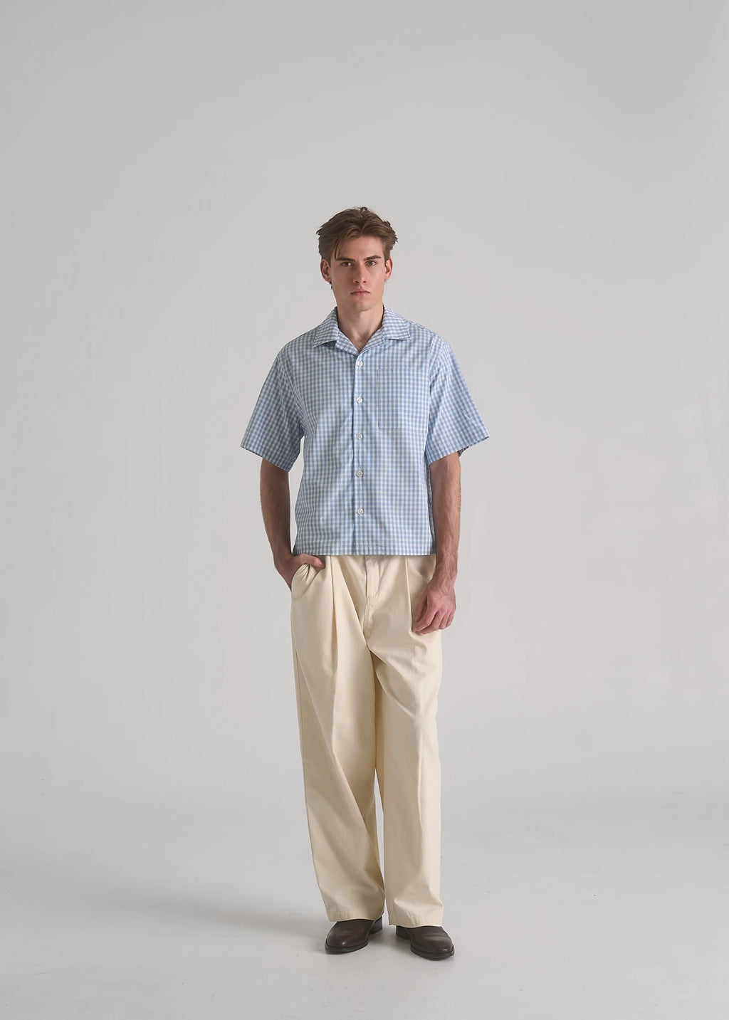 La Corsia Oversized Short Sleeve Shirt in light blue plaid worn by a model on a plain studio background