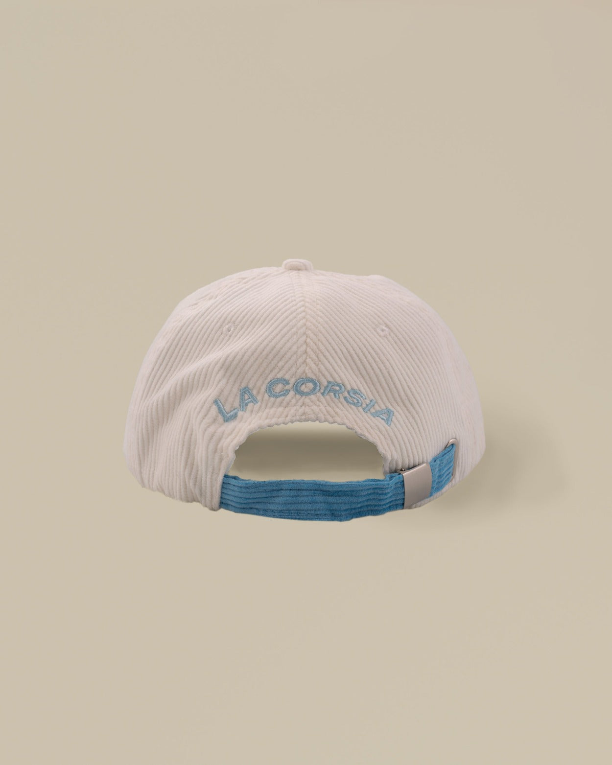 Back view, corduroy cap. La Corsia embroidery, metal buckle. Studio picture.