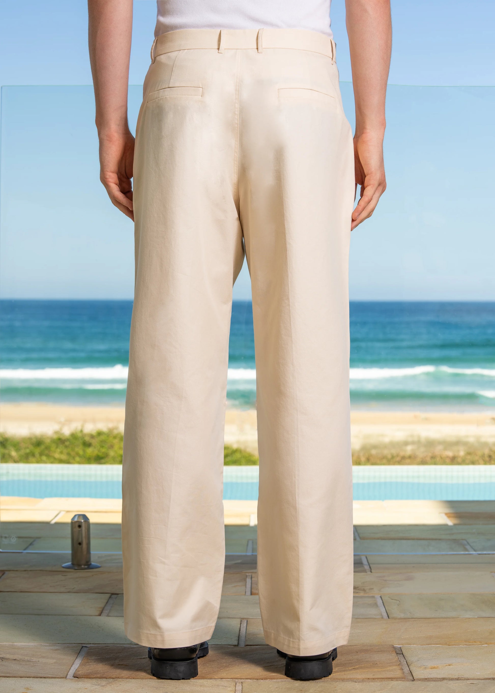 Closeup details of Cream Pleated Pant, beach background. Cotton blend fabric.