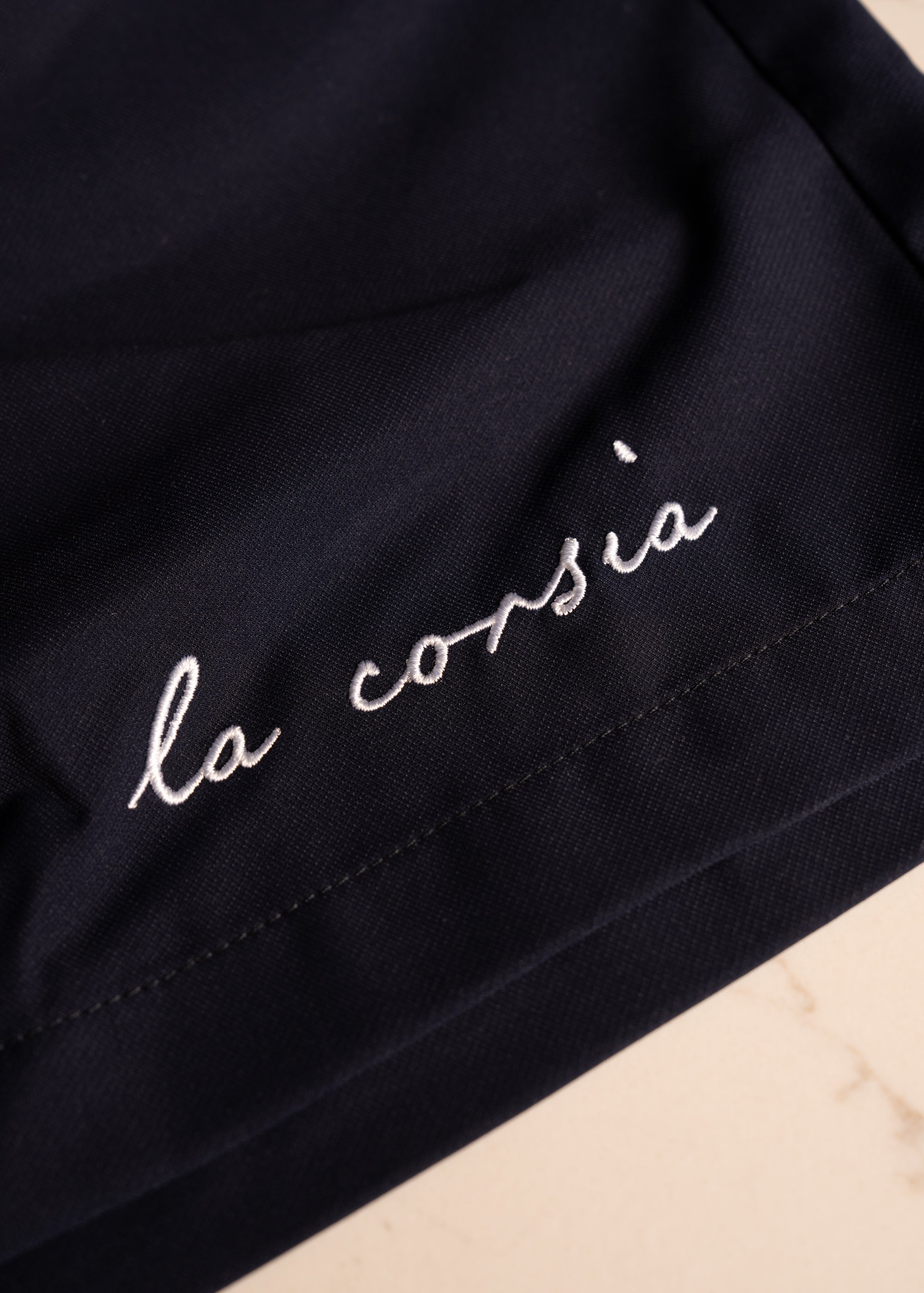 Studio closeup of La Corsia embroidery on Closeup Studio Navy Swim Short La Corsia