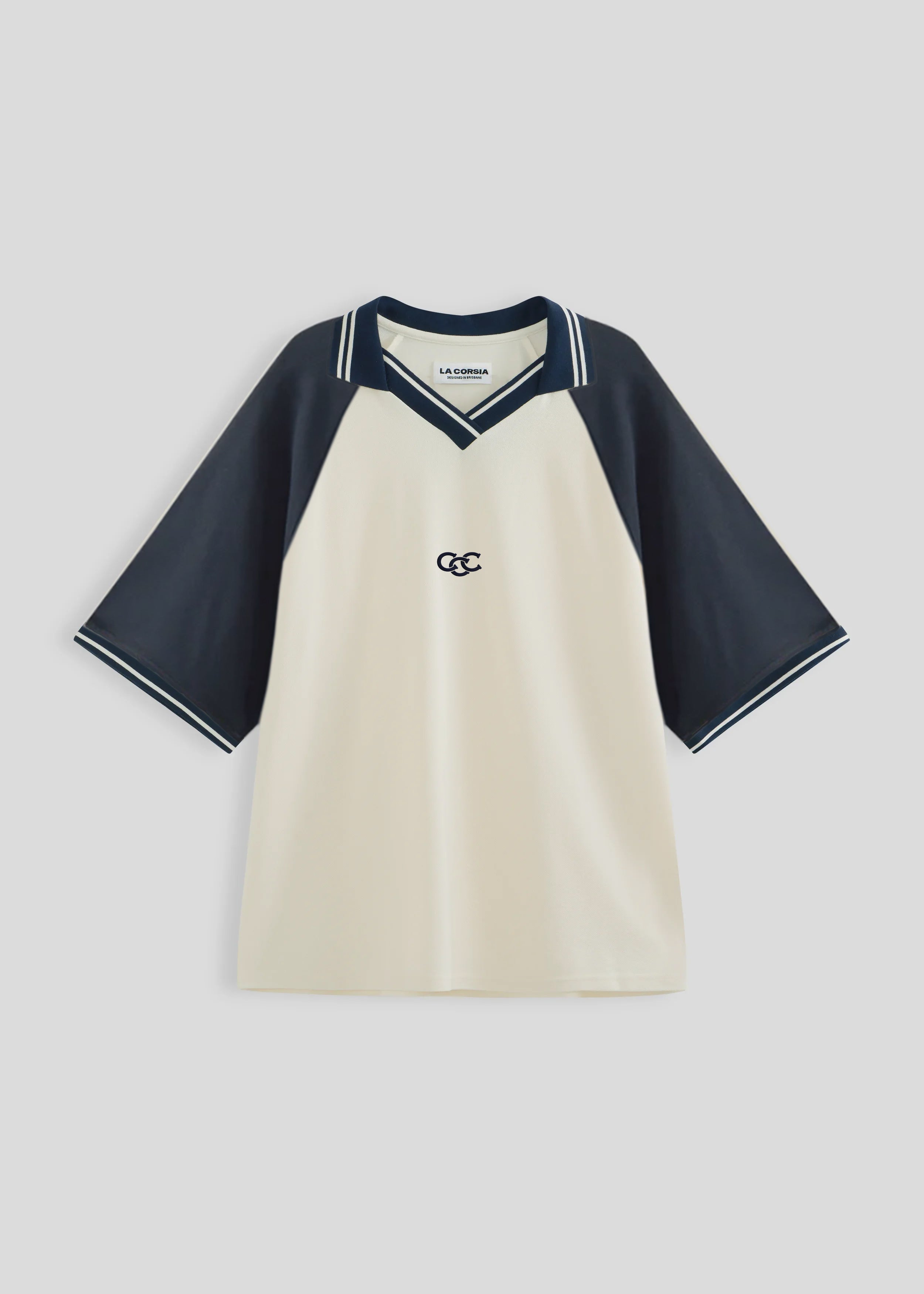 Beige and navy shirt with a logo on a light gray background