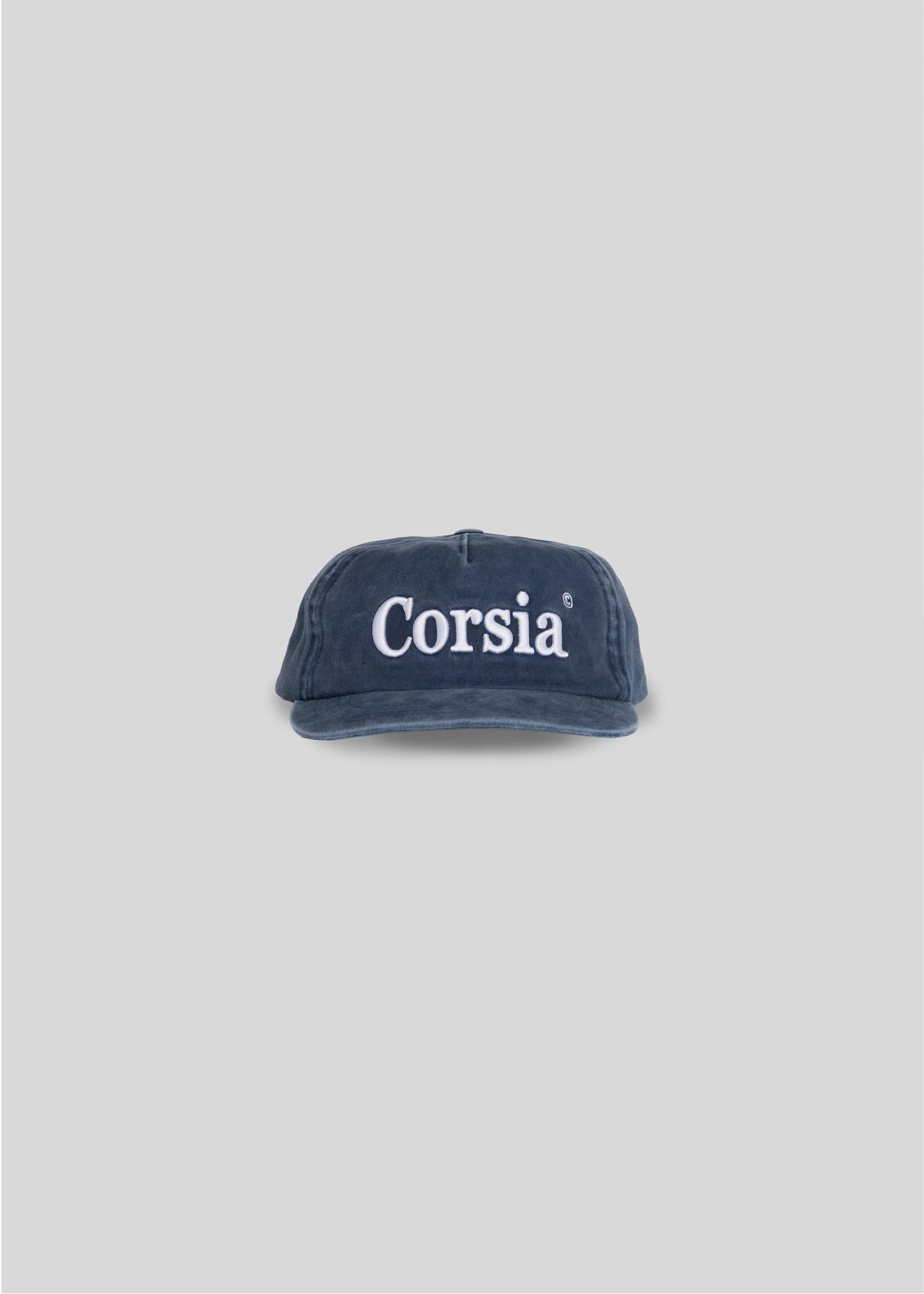 Navy blue cap with 'Corsia' text on a light gray background