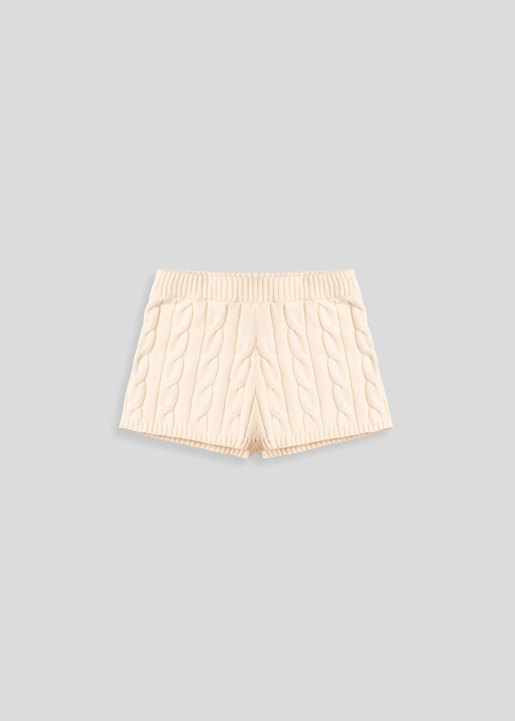 La Corsia Cable Knit Mini Short in cream, made from heavyweight cotton with a fitted silhouette, ribbed waistband, and chunky cable texture throughout.