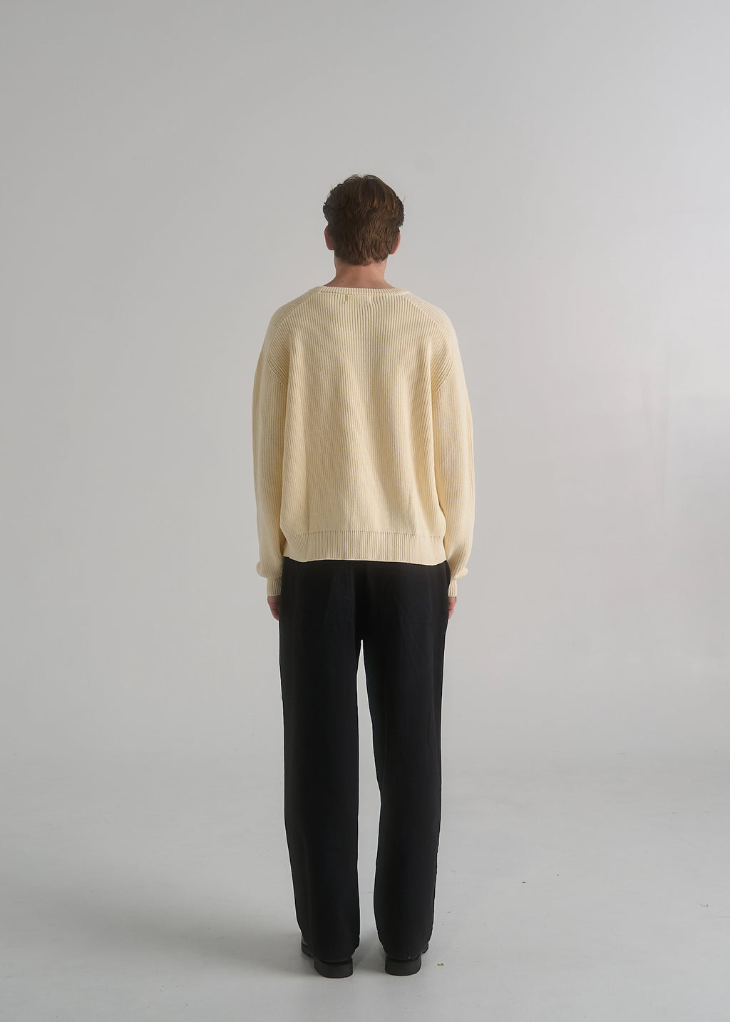 La Corsia Wide Leg Pleated Trouser in washed black, worn by a model on a plain studio background