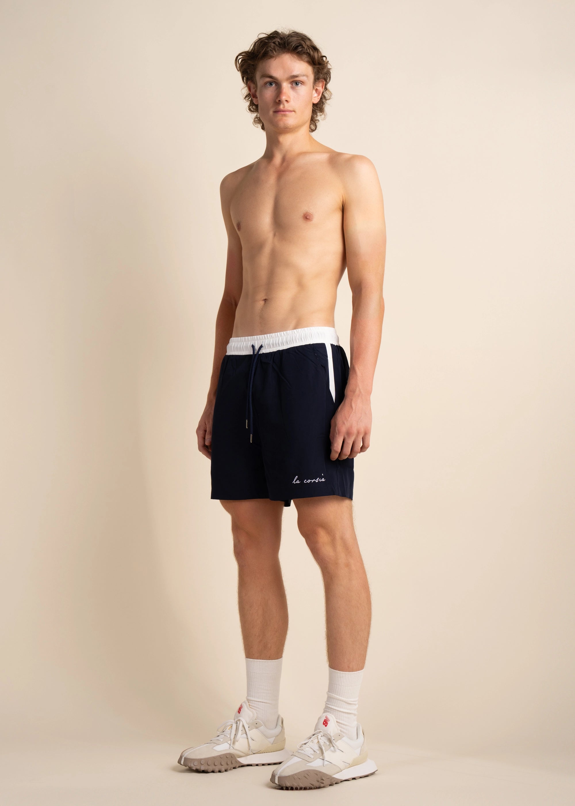 In studio Navy Swim Short model side view.