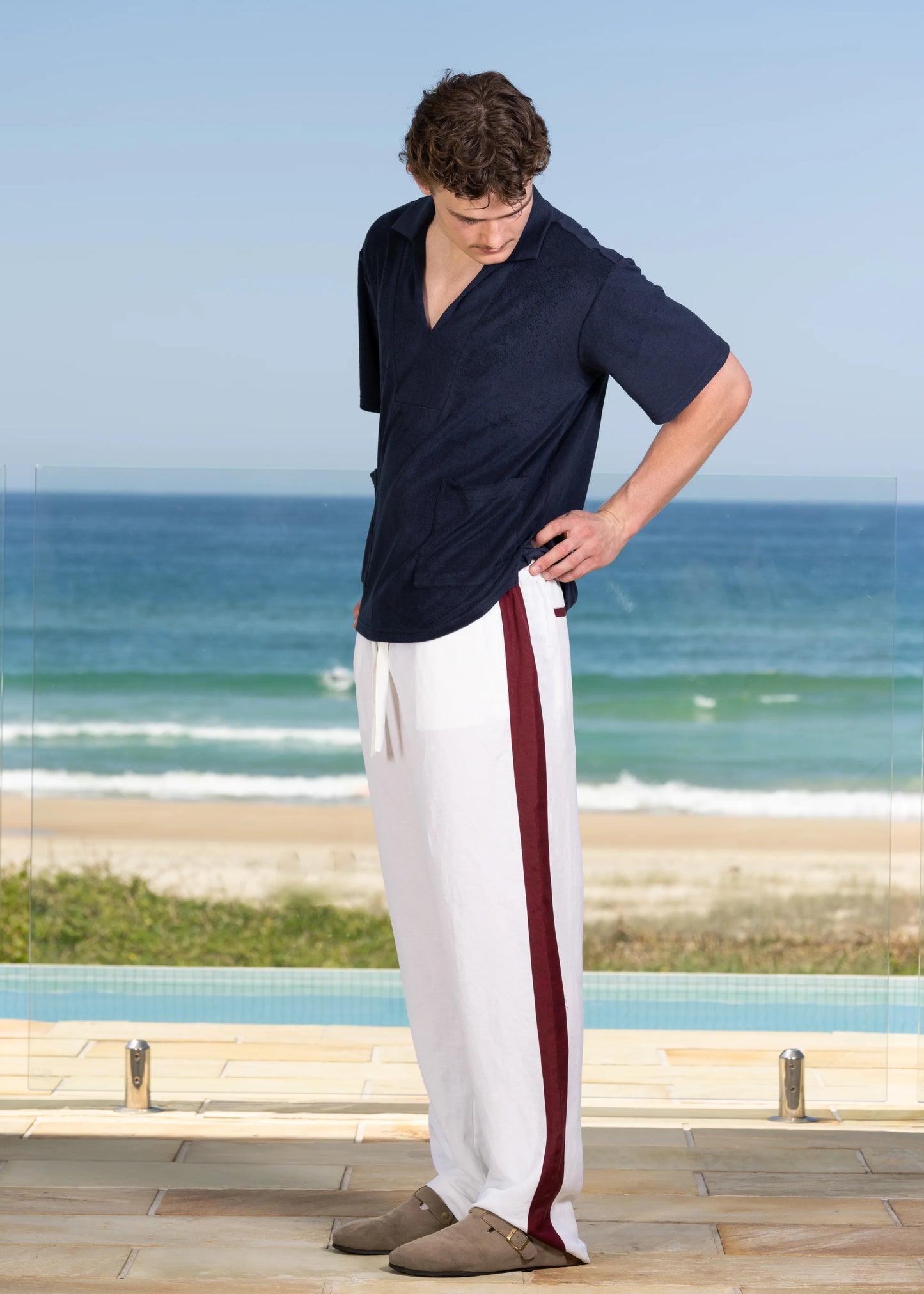 A model wearing the Side Seam Linen Pant on location. Beach background.