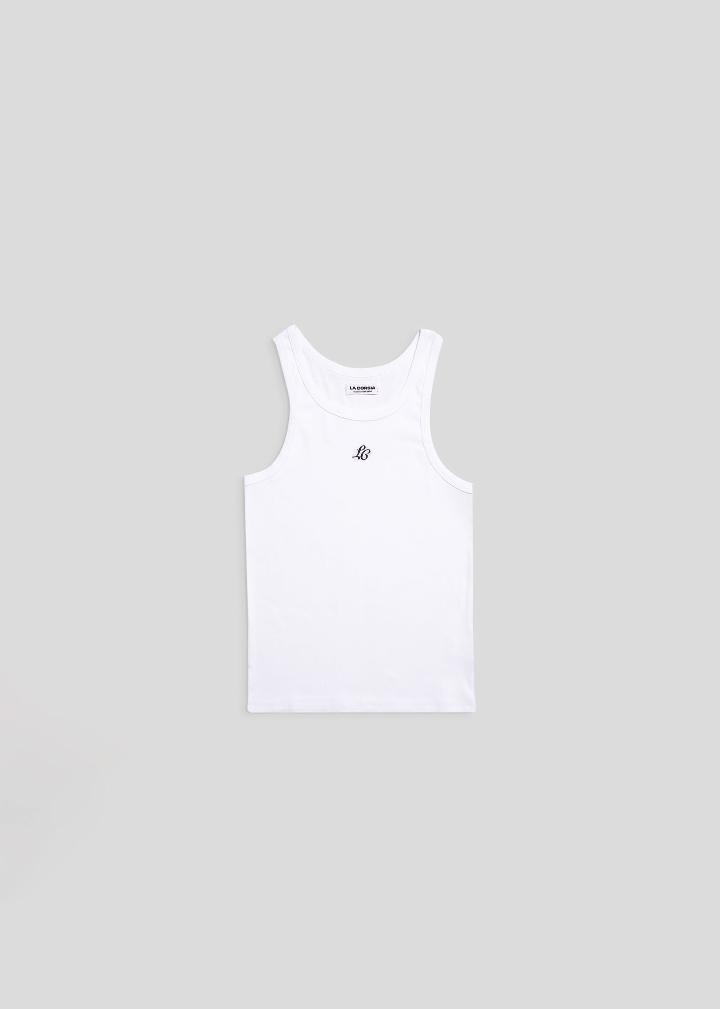 Flat lay of embroidered white monogram tank top by La Corsia, ribbed cotton singlet with LC embroidery